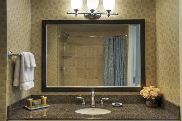 Photo of luxury modern hotel bathroom with mirror and marble counter