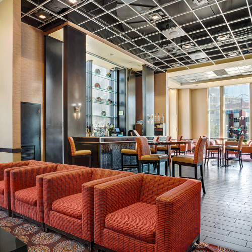 Photo of hotel lounge with multiple red sofas and orange high chairs