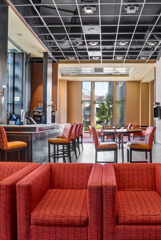 Photo of hotel lounge with multiple red sofas and orange high chairs