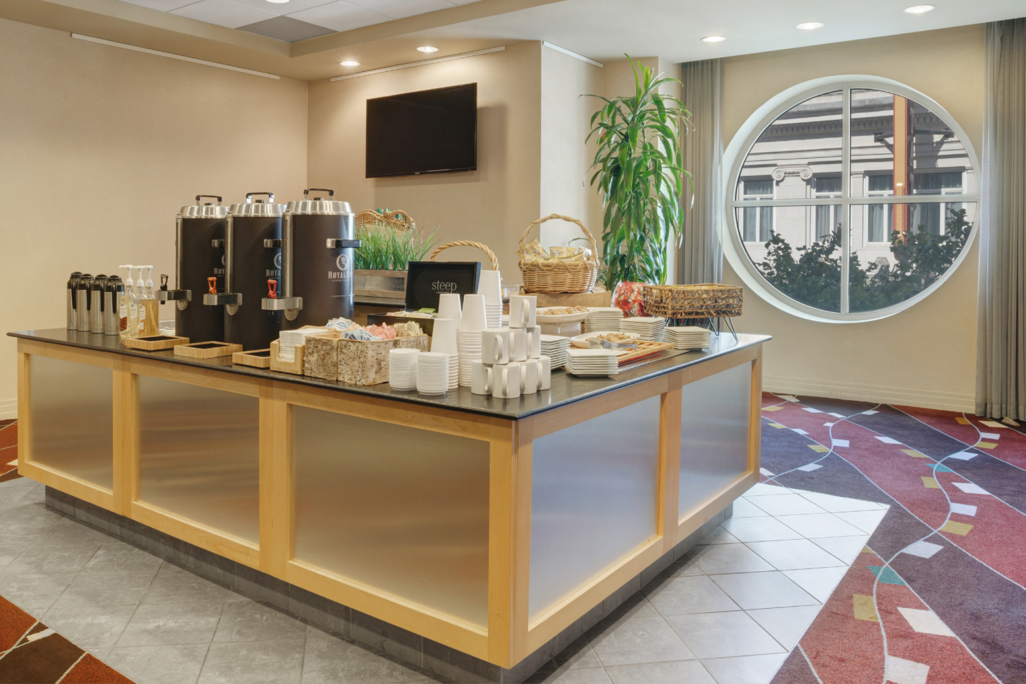 Photo of isle breakfast set up in a multiuse space with an exterior window and carpeted floor