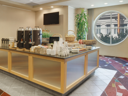 Photo of isle breakfast set up in a multiuse space with an exterior window and carpeted floor