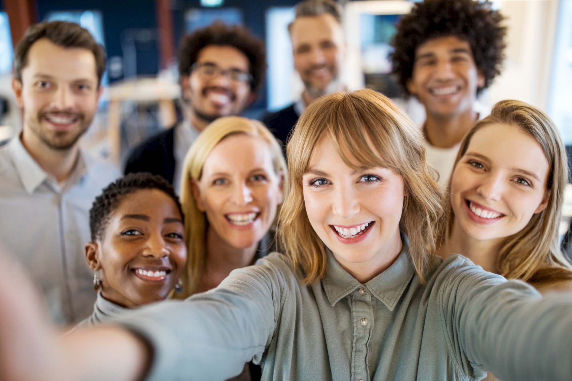 Photo of multiple people smiling on a selfie in business casual attire