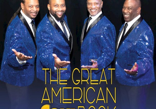 A group of four men in matching blue suits with 