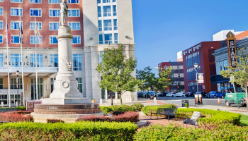 Photo of green grass and statue plaza with hotel building in the back