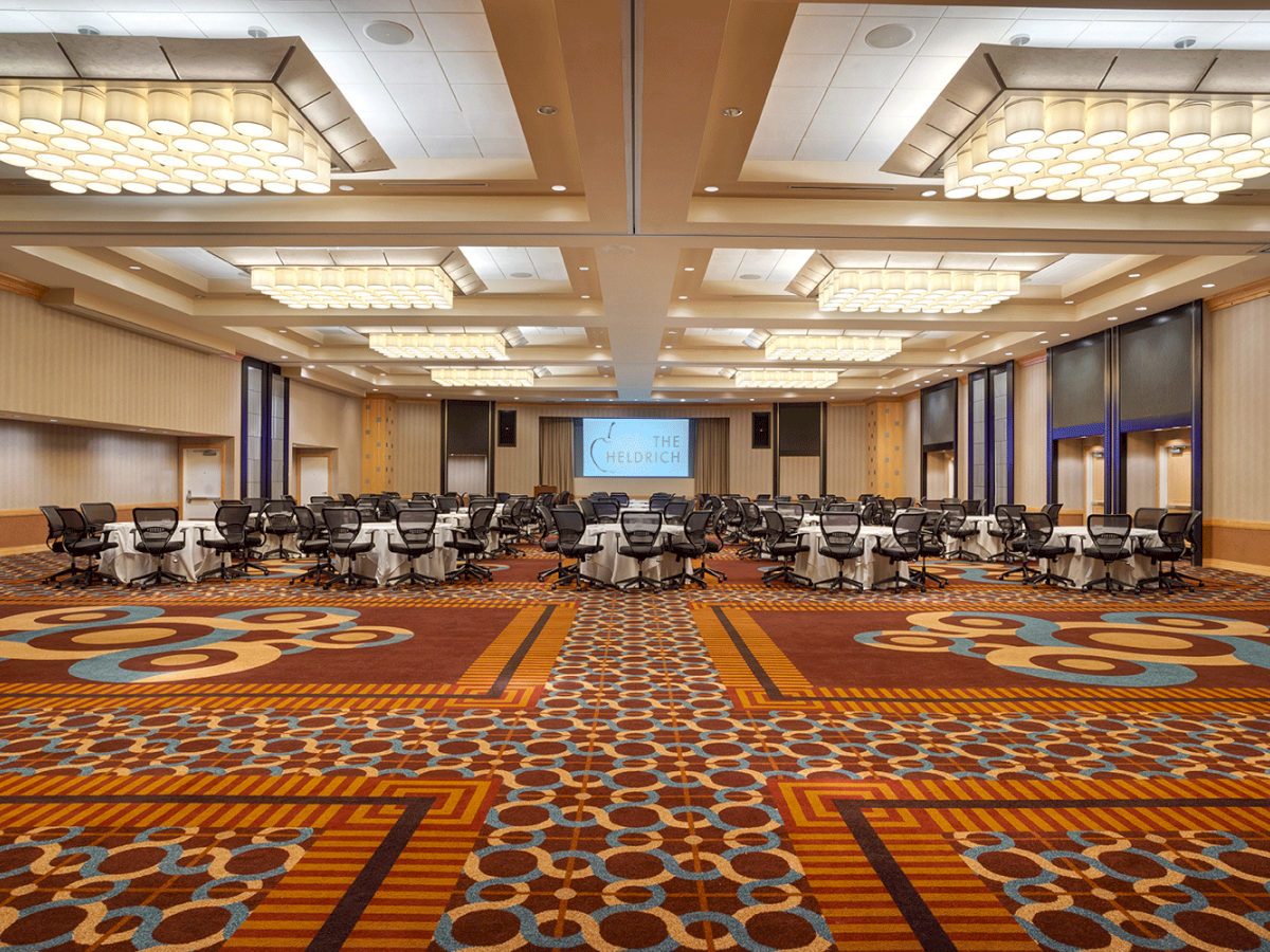 Photo of empty ballroom with chairs and tables in the back of the meeting room