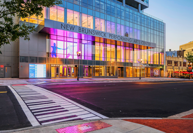 Photo of crosswalk path with a theater in front in an evening set up